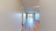 Located at 9901 Lurline Ave in the Chatsworth neighborhood of Los Angeles, this 2-bedroom, 1-bathroom single-story unit offers a well-organized layout across a comfortable footprint. The open living room is a standout feature, showcasing light hardwood-style flooring, a textured ceiling, a ceiling fan, and a large sliding glass door that leads to a private balcony overlooking greenery and mature trees. The space is bright and airy, with natural light flowing throughout.

The galley-style kitchen is thoughtfully designed with crisp white shaker cabinets, quartz-style countertops, a stainless steel sink, and a full suite of stainless steel appliances, including a range, microwave, dishwasher, and refrigerator. The clean, neutral palette gives the kitchen a modern and functional feel.

Both bedrooms feature the same light hardwood-style flooring, neutral gray walls, textured ceilings, and windows that allow natural light in. The primary bedroom is generously sized and includes a closet. The bathroom is clean and straightforward, equipped with a tub/shower combo and light wood-style flooring consistent with the rest of the home. A hallway connects all rooms, completing the efficient single-floor layout.