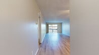 Located at 9901 Lurline Ave in the Chatsworth neighborhood of Los Angeles, this 2-bedroom, 1-bathroom single-story unit offers a well-organized layout across a comfortable footprint. The open living room is a standout feature, showcasing light hardwood-style flooring, a textured ceiling, a ceiling fan, and a large sliding glass door that leads to a private balcony overlooking greenery and mature trees. The space is bright and airy, with natural light flowing throughout.

The galley-style kitchen is thoughtfully designed with crisp white shaker cabinets, quartz-style countertops, a stainless steel sink, and a full suite of stainless steel appliances, including a range, microwave, dishwasher, and refrigerator. The clean, neutral palette gives the kitchen a modern and functional feel.

Both bedrooms feature the same light hardwood-style flooring, neutral gray walls, textured ceilings, and windows that allow natural light in. The primary bedroom is generously sized and includes a closet. The bathroom is clean and straightforward, equipped with a tub/shower combo and light wood-style flooring consistent with the rest of the home. A hallway connects all rooms, completing the efficient single-floor layout.