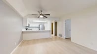 Located at 2170 S Harbor Blvd in Anaheim, CA, this well-appointed one-bedroom, one-bathroom residence offers a clean, modern aesthetic throughout its efficiently designed single-floor layout. Light hardwood flooring extends seamlessly across all rooms, creating a bright and cohesive feel.

The open-concept kitchen and living area serves as the heart of the home. The kitchen features white shaker cabinetry, a skylight overhead, sleek white countertops with a peninsula breakfast bar, and a full suite of stainless steel appliances including a refrigerator, range, and microwave. A ceiling fan with a built-in light fixture anchors the living space, enhancing airflow and comfort.

The spacious bedroom is a standout, offering a generous footprint, large sliding glass doors that open to a private outdoor patio, and access to abundant natural light. A dedicated closet provides organized storage.

The bathroom is clean and functional, finished with white cabinetry and consistent light flooring. Additional storage is available through a separate closet space accessible from the main living area.

The overall ambiance is light, airy, and move-in ready, with a neutral color palette of whites and soft grays that complement the natural brightness throughout the home.