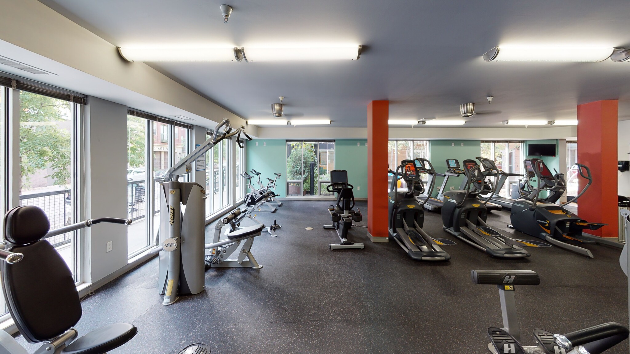 A well-equipped fitness center with cardio machines, weight machines, and bicycles.