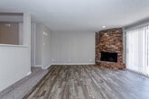 Located on Crabapple Lane in Kansas City, MO, this two-story home offers a thoughtfully arranged layout across two levels. The main living area immediately draws attention with its standout curved brick fireplace, which anchors the corner of the room with a distinctive architectural presence. Wood-look flooring runs throughout the main level, lending warmth and continuity to the space, while a textured ceiling adds subtle character overhead. Large sliding glass doors allow natural light to pour into the living area and provide direct access to an outdoor space.

The kitchen features white shaker-style cabinetry, speckled light countertops, and black appliances including a range, dishwasher, and range hood. A stainless steel sink sits beneath a window, keeping the space bright and functional.

A staircase connects the main level to the upper floor, where carpeted bedrooms offer a quieter retreat. The hallway leads to bathrooms finished with wood-look flooring, white vanity cabinetry, and light countertops. A glass-enclosed shower is also present.

The layout, visible in the 3D floor plan, reveals a well-organized interior with defined zones for living, cooking, and sleeping across both floors.