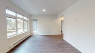 Located at 4255 Maple Street SE in Olympia, Washington, this single-floor residence offers a clean, modern aesthetic throughout. The open living area is finished with durable wood-style flooring and is filled with natural light through large windows that frame views of the surrounding neighborhood. A private entry door adds convenience and accessibility directly from the exterior.

The kitchen is a standout feature, showcasing dark espresso cabinetry contrasted against light countertops and a full suite of stainless steel appliances, including a refrigerator, electric range, microwave, and dishwasher. Recessed lighting and ample cabinet storage make this a highly functional cooking space. A peninsula provides additional prep or dining space and helps define the kitchen's connection to the living area.

The bedroom is carpeted for comfort and includes a window with views to the outdoors, along with a baseboard heating unit. The bathroom is finished with the same dark cabinetry and light countertop pairing found in the kitchen, complemented by a full soaking tub and wood-style flooring. A dedicated in-unit laundry closet houses a stacked Whirlpool washer and dryer, adding practical convenience. The consistent use of neutral tones and modern finishes throughout creates a cohesive and welcoming living environment.