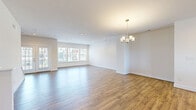 Located at 2271B Libbie Lake W St in Richmond, VA, this well-appointed three-bedroom, five-bathroom home spans three floors and offers a generous, functional layout throughout. The ground level includes an attached garage with an integrated electrical panel, providing convenient and secure parking. The main living floor is expansive and open, featuring a combined kitchen and living room area finished with warm hardwood-style flooring, recessed lighting, and a stylish chandelier. The kitchen is equipped with stainless steel appliances, including a gas range, microwave, and French door refrigerator, complemented by gray shaker-style cabinetry, a center island with a clean white countertop, and ample storage. Large windows flood the living area with natural light and provide views of the surrounding community. The upper floor houses the bedrooms, each fitted with plush carpet, ceiling fans, and natural light. The spacious primary bedroom includes a closet and access to a well-finished en-suite. The five bathrooms feature elegant stone-look tile work, including a soaking tub and a glass-enclosed walk-in shower. A dedicated laundry room with full-size washer and dryer adds everyday convenience. Two closets and multiple hallways further enhance the home's practical design.