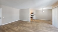 Located at 1022 N Jackson St in Glendale, California, this single-story unit has been thoughtfully updated with a consistent, modern aesthetic carried throughout every room. Light-toned luxury vinyl plank flooring flows seamlessly across the living, dining, and bedroom areas, lending warmth and visual continuity to the space.

The open living and dining area is generously proportioned, with neutral warm-gray walls and natural light filtering in through large windows and a sliding glass door fitted with vertical blinds. A contemporary chandelier anchors the dining area, adding a refined touch to the otherwise clean-lined design.

The kitchen is efficiently laid out in a galley configuration, featuring crisp white shaker cabinetry, white quartz countertops, a stainless steel sink with a matte black faucet, and stainless steel appliances including a range and microwave. A small breakfast bar provides additional seating and connects the kitchen to the main living area.

The bedrooms are bright and well-sized, each with wide windows that allow ample natural light. Hallway access leads to closets with sliding doors and two bathrooms. Both bathrooms feature white cabinetry with brushed nickel or matte black hardware, white quartz countertops, framed mirrors, and updated lighting. One bathroom includes a walk-in shower with a glass door and chrome fixtures, while the other offers a tub-shower combination.