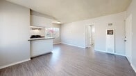 Located at 890 S Rosemead Blvd in Pasadena, CA, this 2-bedroom, 1-bathroom unit offers a functional and well-appointed single-floor layout. The open-concept living and dining area features wood-style laminate flooring, a textured ceiling, and large windows with vertical blinds that allow abundant natural light to fill the space. The kitchen is equipped with white cabinetry, dark granite countertops, a gas range, dishwasher, and refrigerator — all in black — complemented by an over-range ventilation hood and a peninsula that connects seamlessly to the living area. Both bedrooms are carpeted and receive natural light through vertical-blind windows. The primary bedroom includes mirrored sliding closet doors, adding a sense of depth and brightness to the room. The second bedroom also features a window unit for climate control. Three closets throughout the unit provide generous storage. The bathroom is finished with stone-tile flooring, a white vanity with granite countertop, a large mirror, and a tub-shower combination. A connecting hallway ties the layout together efficiently. The unit's neutral color palette and practical finishes create a clean, move-in-ready atmosphere.