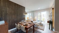 Located at 13081 SW 242nd St, Unit 116 in Homestead, FL, this thoughtfully designed single-story residence combines modern aesthetics with functional living. The open-concept layout seamlessly connects the dining and living areas, anchored by a striking dark wood-paneled accent wall that adds warmth and texture. A large floor-to-ceiling mirror amplifies the sense of space and reflects natural light, while sliding glass doors open to an outdoor view, flooding the interior with brightness. The dining area features a wooden table with contemporary white chairs beneath a stylish pendant light. The living room offers a plush sofa, a sleek white coffee table, and built-in media storage against a complementary wood-textured wall. The kitchen is well-appointed with dark cabinetry, stainless steel appliances, light wood flooring, a butcher-block island, and generous counter space. The primary bedroom is serene and light-filled, with sheer curtains, a mirrored wall panel, and a tufted upholstered headboard. A secondary room provides flexible use, offering a comfortable, versatile space with ample natural light. The bathroom presents a clean, minimalist design with a granite-topped dark vanity, a large mirror, and crisp white finishes throughout.