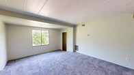 Located at 957 Bockstoce Ave in Castle Shannon, PA, this single-floor home offers four bedrooms, one bathroom, a kitchen, and a dedicated closet, all within a practical and well-organized layout. The living areas are finished with plush carpeting throughout, providing a comfortable, cohesive feel across the space.

The generously sized primary bedroom offers ample room, neutral wall tones, and natural light from a large window with views of surrounding greenery. The additional bedrooms are similarly appointed, with soft carpeting, ceiling fans in select rooms, and wall sconce lighting — offering functional, move-in-ready spaces.

The updated kitchen features crisp white shaker-style cabinetry, granite-look countertops, a stainless steel sink, and a stainless steel refrigerator, all set over warm wood-look flooring that adds a welcoming contrast to the bright cabinetry.

The bathroom is clean and modern, with white vanity cabinetry, a medicine cabinet mirror, and wood-look flooring that ties seamlessly into the kitchen's aesthetic. A dedicated walk-in closet with dual hanging rods provides excellent storage capacity.

Throughout the home, panel ceilings, neutral gray walls, and consistent finishes create a clean, understated atmosphere suited for comfortable everyday living.