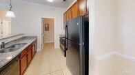 Located at 101 Palisades Dr in Lincolnton, NC, this single-story, 3-bedroom, 3-bathroom home offers a thoughtfully designed layout with a comfortable and functional flow throughout. The combined dining room, kitchen, and living area form the heart of the home, where the kitchen stands out with rich wood cabinetry, granite countertops, tile flooring, and black appliances including a full-size refrigerator and range. Crown molding and chair-rail detailing in the dining area add a classic architectural touch. The bedrooms are carpeted and bathed in natural light through large windows with outdoor views of lush greenery. The spacious primary bedroom features crown molding, a ceiling fan with light fixture, and a recessed window nook that enhances its sense of openness. Each bathroom is finished with warm-toned tile flooring, rich cherry wood vanities, and granite countertops. The dedicated laundry room includes wire shelving and utility hookups for added convenience. Three closets provide ample storage throughout the home. With neutral tones, consistent finishes, and a bright, airy atmosphere, this home presents a clean and welcoming living environment.
