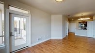 Located at 6979 Birdseye Avenue NE in Lacey, Washington, Unit 413 is a thoughtfully designed single-floor residence that balances modern finishes with functional living spaces. The open-concept living and dining area features warm wood-look flooring, neutral-toned walls, and large windows that invite natural light, including a glass-panel door leading to a private balcony with outdoor views. A pendant light fixture adds a refined touch to the dining space. The well-appointed kitchen is a standout feature, offering rich dark-stained cabinetry, white countertops, black appliances including a range, microwave, and refrigerator, and a peninsula with a single-basin sink. A dedicated pantry with built-in shelving provides generous storage. The bedroom is carpeted for comfort and includes access to a walk-in closet and an en-suite bathroom. The bathroom is finished with matching dark cabinetry, a single-sink vanity, wood-look flooring, and a full soaking tub with shower. Additional highlights include a secondary closet in the bedroom, recessed lighting throughout, and a clean, neutral palette that creates a bright and welcoming atmosphere throughout the unit.