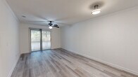 Located at 900 Dilworth St in Saint Marys, Georgia, this single-floor, one-bedroom, three-bathroom residence offers a clean and functional layout across a comfortable footprint. The open entryway leads down a bright hallway with light-toned luxury vinyl plank flooring that carries through the main living spaces. The living room is a generously sized area featuring a ceiling fan, crown molding, and a sliding glass door that opens to a private balcony, allowing natural light to fill the space and offering pleasant views of the surrounding greenery. A separate dining room provides dedicated space for meals and gatherings. The kitchen is well-equipped with rich, warm-toned wood cabinetry, dark granite countertops, a stainless steel sink, a dishwasher, and tile flooring — a combination that delivers both style and practicality. The bedroom is a comfortably sized retreat with plush carpeting and a window that brings in natural light. Three bathrooms feature tile flooring and vanities consistent with the kitchen's design aesthetic, providing ample convenience. Additional highlights include three closets for generous storage, a dedicated laundry room with washer hookups, and a hallway connecting the living spaces seamlessly throughout the home.