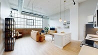 Located at 628 Ellicott St in Buffalo, NY, this one-bedroom, one-bathroom loft blends industrial character with modern finishes across a thoughtfully designed single floor. The open-concept kitchen and living area serves as the heart of the space, anchored by soaring ceilings with exposed ductwork and dramatic oversized factory windows that flood the room with natural light. Original brick walls add warmth and texture, complementing the light hardwood flooring found throughout. The kitchen is outfitted with white shaker cabinetry, stainless steel appliances, a geometric tile backsplash, and a large island with pendant lighting above — ideal for both cooking and casual dining. The living area offers generous room to relax, framed by the striking industrial windows. The bedroom is a serene retreat with elevated ceilings, high clerestory windows, and access to two closets. The full bathroom features floor-to-ceiling marble-look tile, a sliding glass walk-in shower, and a white vanity with gold-accented fixtures. A dedicated laundry area adds everyday convenience. This loft delivers an exceptional combination of open, airy living and refined urban design.