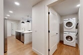 Located at 1557 N Logan St in Denver, CO, this contemporary one-bedroom, one-bathroom residence offers a thoughtfully designed single-floor layout with modern finishes throughout. Light hardwood flooring flows seamlessly across the entire space, creating a warm and cohesive aesthetic.

The kitchen is a standout feature, anchored by a large white waterfall island with a gold-accented sink and dual pendant lighting overhead. Dark cabinetry extending floor-to-ceiling provides generous storage, while stainless steel appliances—including a gas range, French door refrigerator, and built-in microwave—complete the chef-inspired setup. A subtle tile backsplash adds texture against the crisp white countertops.

The bedroom is a comfortable, well-proportioned retreat featuring a ceiling fan, a built-in beverage cooler with open shelving, and direct access to a private outdoor patio through a glass panel door—bringing in abundant natural light and views of the surrounding neighborhood.

The bathroom is finished in a clean, modern style with large-format tile in the walk-in glass shower, matte black hardware throughout, and warm wood-look flooring. An in-unit stacked washer and dryer add everyday convenience, tucked neatly into a dedicated laundry area. A closet completes the practical layout of this well-appointed Denver residence.