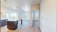 Located at 9990 E Harvard Ave in Denver, CO, this well-appointed 2-bedroom, 2-bathroom residence offers a thoughtfully designed single-floor layout with a clean, modern aesthetic. Light wood-tone flooring flows seamlessly throughout the space, complementing the crisp white walls and creating a bright, cohesive atmosphere.

The kitchen serves as a central hub, featuring a two-tone design with white upper cabinetry and dark espresso lower cabinets, a white quartz countertop island, stainless steel appliances including a refrigerator, range, microwave, and dishwasher, and a subway tile backsplash. The kitchen opens directly to the living area, enhancing the open-concept feel.

The living area benefits from large windows fitted with horizontal blinds and a ceiling fan, while a sliding glass door leads to a private balcony with views of the surrounding Denver treeline. Both bedrooms include ceiling fans and generous windows, with the primary bedroom offering direct access to its own bathroom. Each bathroom is finished with dark wood vanities, white quartz countertops, subway-tiled tub-and-shower combinations, and light wood flooring. Two closets provide practical storage throughout the residence.