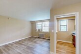 Located at 4512 MacArthur Blvd NW in Washington, DC's desirable Georgetown/Palisades neighborhood, this one-bedroom, one-bathroom unit offers a well-organized single-floor layout. Light wood-style flooring runs continuously throughout the space, lending a clean, cohesive aesthetic to every room.

The living room is a comfortable, open area with warm neutral-toned walls, large windows that invite abundant natural light, and a classic white radiator for heating. A window-unit air conditioner provides additional climate control. A pass-through window connects the living area directly to the kitchen, which features warm wood cabinetry and stainless steel appliances, creating a functional and connected layout.

The bedroom is a well-proportioned retreat with two closets providing ample storage, a ceiling fan with a light fixture, a window with natural light, and a radiator. The warm, neutral palette continues here, maintaining a consistent and calming ambiance throughout.

A connecting hallway links the main living areas to the bathroom, which includes a full tub and shower combo with white tile surround and chrome fixtures, along with a window for natural ventilation and light.

The layout flows logically from room to room, making efficient use of the available space. Clean finishes and neutral tones throughout make this unit a move-in ready home in a prime DC location.