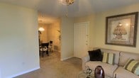 Located at 4315 Highway 39 N in Meridian, Mississippi, this single-story property offers a cohesive and functional layout designed for comfortable everyday living. The interior is finished with wall-to-wall carpeting throughout, lending a warm and inviting atmosphere to the main living areas. The living room serves as a welcoming entry point into the home, featuring soft neutral wall tones, white panel doors, and a decorative ceiling fixture that adds a touch of character overhead. The space flows naturally into the dining area, which is illuminated by a classic chandelier that casts a warm glow over the room. The open sightline between these two areas creates a sense of connectivity, making the floor plan feel both practical and spacious. The soft, muted color palette of warm beige and cream tones is consistent throughout, contributing to a calm and understated aesthetic. The single-floor design ensures easy accessibility across all areas of the property. Overall, the space presents a straightforward and comfortable living environment well-suited for those seeking a functional home in the Meridian, Mississippi area.