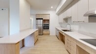 Located at 3250 Boul Henri-Bourassa E in Montréal, this well-designed 2-bedroom, 1-bathroom unit offers a clean, contemporary aesthetic across a thoughtfully laid-out single floor. Light hardwood flooring flows consistently throughout the space, complemented by crisp white walls and recessed lighting that create a bright, airy atmosphere.

The kitchen is a standout feature, boasting light wood cabinetry paired with upper grey cabinets, white quartz countertops, and stainless steel appliances including a French door refrigerator, double wall oven, and dishwasher. A central island provides additional prep and storage space, seamlessly connecting the kitchen to the living area.

The spacious living room benefits from large sliding glass doors that open to an outdoor area, flooding the space with natural light and offering pleasant garden views. A wall-mounted mini-split unit provides efficient climate control.

Both bedrooms are generously proportioned, featuring light hardwood floors, white panel doors with closets, and windows that allow for natural light. Baseboard heating provides additional comfort in the bedrooms.

The bathroom is finished with large-format stone-look floor tiles, a combined soaking tub and shower with a handheld fixture, and warm wood cabinetry, delivering a clean and functional design. Two hallways provide practical circulation throughout the unit.