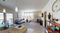 This single-floor residence offers a thoughtfully designed layout that balances comfort and functionality. The open-concept living and dining area is bright and welcoming, filled with natural light from large windows that overlook the surrounding exterior. The living space features plush carpeting, neutral-toned walls, and room for generous seating arrangements, creating an inviting atmosphere for both relaxing and entertaining.

The kitchen is well-equipped with rich cherry-toned cabinetry, granite countertops, and a full suite of stainless steel appliances including a refrigerator, electric range, and built-in microwave. Light wood flooring runs throughout the kitchen, which also benefits from direct access to the balcony through sliding glass doors.

Two bedrooms provide comfortable private retreats, each with carpeted floors, natural light from exterior-facing windows, and neutral décor. One bedroom includes a spacious walk-in closet outfitted with dual hanging rods and shelving. The two bathrooms are clean and functional — one features a tub/shower combo and wood-look flooring, while the other offers a double-sink vanity with dark wood cabinetry, also finished with wood-look flooring. Together, these spaces offer a cohesive, modern living experience.