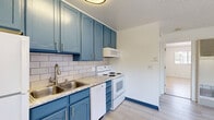 Located on E Taylor Street in Reno, Nevada, this one-bedroom, one-bathroom unit offers a practical and well-appointed single-floor layout. Light wood-style flooring runs throughout the space, lending a clean and cohesive aesthetic to every room.

The kitchen is a standout feature, showcasing bold teal cabinetry with brushed gold hardware paired with a classic white subway tile backsplash and light granite-style countertops. A double-basin stainless steel sink, full suite of white appliances — including a refrigerator, electric range, microwave, and dishwasher — and ample upper and lower cabinet storage make this a fully functional cooking space.

The bedroom is comfortably sized, featuring a window that brings in natural light and contributes to the room's bright, airy feel. The textured ceiling and neutral white walls keep the space versatile and move-in ready.

The bathroom is neatly designed with wood-style flooring, a white vanity with a mirrored medicine cabinet, and a tub/shower combo with earth-toned tile surround and frosted glass sliding doors.

Additional spaces include a closet and a utility room, maximizing the unit's storage and functionality. The overall design balances simplicity with thoughtful updates, making it a practical option in the Reno area.