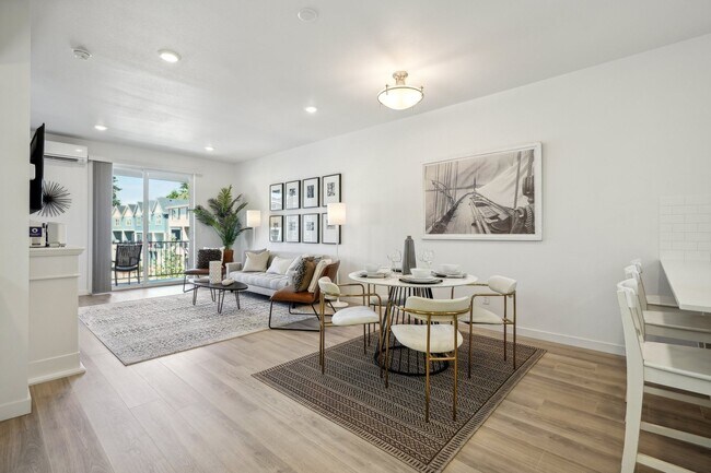 El amplio diseño de planta abierta acomoda un taburete, un juego de comedor completo y muebles de sala de estar. - Holmes Park Townhomes