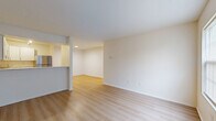 Located in Village Green Court in Newark, Ohio, this single-floor, two-bedroom, two-bathroom unit offers a functional and well-designed layout. The open-concept living, dining, and kitchen area is bathed in a bright, neutral palette and finished with light wood-style flooring that flows seamlessly throughout the main spaces. The kitchen is equipped with stainless steel appliances—including a refrigerator, range, and dishwasher—white shaker-style cabinetry, light countertops, and track lighting overhead, providing both style and practicality. A peninsula-style counter connects the kitchen to the dining and living area, maximizing usability of the shared space. The spacious primary bedroom features plush carpet, a natural window, recessed lighting, and access to a walk-in closet outfitted with wire shelving and built-in organizers. The second bedroom is also carpeted with a window allowing natural light. Each bathroom is clean and efficiently designed—one includes a soaking tub, while the other features a dedicated walk-in shower. In-unit laundry is conveniently located within one of the bathrooms. The overall ambiance is clean, bright, and move-in ready, making this a practical and comfortable home.