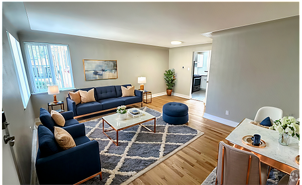 Chic and cozy apartment featuring a bright living area with plush seating and modern decor. Hardwood floors and large windows create an inviting atmosphere in this 1 bed, 1 bath unit for $1,350 per month. - Flats at 16th