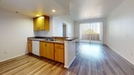 Located at 38832 Fourth St E in Palmdale, California, this single-story, one-bedroom, one-bathroom unit offers a practical and comfortable layout designed to maximize its efficiently used floor space. Throughout the unit, wood-look laminate flooring in warm, neutral tones provides a cohesive and modern aesthetic.

The open-concept kitchen connects seamlessly to the living area, making the space feel larger and more versatile. The kitchen features warm honey-toned wood cabinetry, a dual-basin sink set into a dark laminate countertop, a dishwasher, and white appliances including a full-size refrigerator and an electric range with overhead cabinetry for ample storage. Recessed lighting illuminates the kitchen area, while a sliding glass door with vertical blinds floods the adjacent living space with natural light and provides outdoor access.

The bedroom is a comfortable, well-proportioned room with a window that invites natural light and outdoor views, complemented by the same wood-look flooring found throughout the unit. A dedicated hallway closet with a rod and shelving provides generous storage.

The bathroom is clean and functional, featuring a shower-tub combination with a curved rod, a toilet, a vanity with wood cabinetry, and direct access to the closet. A central hallway connects all rooms, ensuring an efficient and logical flow throughout the unit.