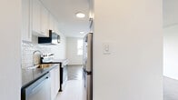 Located on the third floor at 1050 Castlefield Avenue in Toronto's vibrant Midtown neighbourhood, this one-bedroom, one-bathroom unit offers a well-organized and functional layout across a single level. The living area is bright and open, featuring classic parquet flooring throughout and large windows that invite natural light and offer views of the surrounding cityscape. A radiator provides supplemental warmth, adding a nod to the building's established character. The space flows naturally from the living area toward a hallway connecting the bedroom and bathroom. The bedroom is a comfortable size, complete with sliding closet doors for built-in storage, parquet flooring, and a window that continues the theme of natural light. The galley-style kitchen is efficiently designed with white shaker cabinetry, subway tile backsplash, dark countertops, and stainless steel appliances including a refrigerator, stove, and built-in microwave — maximizing every inch of the space. The bathroom is clean and modern, finished with floor-to-ceiling white subway tiles, a soaking bathtub, and a streamlined vanity with a white basin. Throughout the unit, the white walls and light flooring create a bright, neutral palette well-suited to a variety of interior styles.