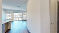 This well-appointed one-bedroom, one-and-a-half-bathroom residence in Austin, TX offers a thoughtfully designed open-concept layout that maximizes comfort and functionality. The living room is bathed in natural light through expansive sliding glass doors that open to a private balcony overlooking the surrounding community, complemented by a ceiling fan and rich hardwood-style flooring that flows throughout the main living areas. The gourmet kitchen is a standout feature, outfitted with stainless steel appliances including a double oven range, French door refrigerator, and dishwasher, alongside warm wood cabinetry, a sleek ventilation hood, and crisp white countertops. The spacious primary bedroom offers plush carpeting, a generous walk-in closet with built-in shelving, and direct access to the en-suite bathroom. The primary bath is elegantly finished with a glass-enclosed shower, a soaking tub, dual vanity sinks, and hardwood-style flooring. A half bathroom provides added convenience for guests. Clean white walls, modern hardware, and consistent finishes throughout create a cohesive, contemporary aesthetic well-suited for everyday Austin living.
