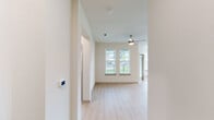This well-designed 2-bedroom, 2-bathroom single-story residence at 8025 Monty Stratton Pkwy in Greenville, TX offers a clean, modern aesthetic with thoughtful details throughout. Light wood-style flooring flows seamlessly across the entire unit, creating a cohesive and bright atmosphere. The open-concept kitchen serves as the heart of the home, showcasing grey shaker-style cabinetry, granite countertops, a central island with pendant lighting, stainless steel appliances, and a subway tile backsplash — all designed for both functionality and style. The living area extends naturally from the kitchen and features a ceiling fan, two large windows, and a glass door that invites natural light and outdoor views. Both bedrooms are comfortably proportioned, each equipped with a ceiling fan and windows overlooking the surrounding greenery. The primary bedroom connects to a dedicated en-suite bathroom, while the second full bathroom features a tiled tub-shower combination, wood-style flooring, and a granite-topped vanity. Additional features include two closets, two hallways for convenient circulation, and recessed lighting. The overall ambiance is clean, contemporary, and move-in ready.