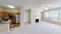 Located at 100 Northcreek Dr in Durham, NC, this single-floor residence offers a well-designed layout with a comfortable, neutral-toned interior throughout. The open living area is anchored by a classic fireplace with a white surround and built-in display shelves, complemented by crown molding, plush carpet, and a ceiling fan with light fixture. Natural light flows in through multiple windows, and a glass-paned door provides access to the exterior. The kitchen is efficiently designed with warm wood cabinetry, granite-style countertops, a double stainless steel sink, and a full suite of stainless steel appliances including a range, over-the-range microwave, refrigerator, and dishwasher. Hardwood-style flooring adds warmth to the kitchen area. The bathrooms are well-appointed, each featuring dark wood vanities, granite-style countertops, and large framed mirrors with overhead lighting. One bathroom includes a double-sink vanity, while another offers a combined tub and shower with sliding glass doors. The bedrooms are generously sized, finished with soft carpet and windows that bring in natural light, providing a calm and functional retreat. The space presents a consistent, cohesive aesthetic throughout.