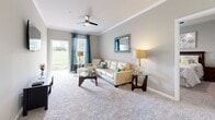 Located at 135 Westfield Ct in Clarksville, Tennessee, this well-appointed single-floor residence offers a thoughtfully designed layout with a cohesive neutral color palette throughout. The spacious living room features plush carpet, crown molding, a ceiling fan, and large sliding glass doors that flood the space with natural light and provide direct views of the surrounding greenery. Adjacent to the living area, the dining room offers an intimate setting with crown molding and ample space for a full dining set. The kitchen is equipped with stainless steel appliances, white cabinetry, light stone countertops, a peninsula with sink, and wood-look flooring, with direct access to a dedicated in-unit laundry room that accommodates a full-size washer and dryer. The primary bedroom features plush carpet, a ceiling fan, a large window with outdoor views, and leads to a full bathroom with a vanity and a tub-shower combination. A generously sized walk-in closet with wire shelving provides abundant storage. The second bedroom is equally comfortable, with soft carpet and its own closet access. A second full bathroom mirrors the quality finishes seen throughout, with wood-look flooring and a tub-shower. Every room reflects a clean, functional design suited for comfortable everyday living.