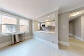 Located at 1535 Bathurst St in Toronto's midtown neighbourhood, this one-bedroom, one-bathroom unit combines classic architectural character with clean, modern updates. Light-toned hardwood-style flooring runs throughout, complemented by neutral warm-grey walls and crisp white trim and baseboards, creating a bright and cohesive aesthetic.

The combined living and kitchen area is efficiently laid out, with the kitchen positioned behind a half-wall pass-through that opens to the living space. The kitchen is equipped with stainless steel appliances, including an electric range, dishwasher, and refrigerator, along with white cabinetry, a white countertop, and a grey subway tile backsplash. A window above the kitchen brings in natural light. A decorative white fireplace mantel serves as a standout feature in the living area, adding timeless character to the space.

The bedroom is a comfortable size, featuring two windows that allow natural light to enter, a classic cast-iron radiator, and a sliding-door closet for storage. An additional door leads to extra storage space.

The bathroom is finished in crisp white, featuring a soaking tub, tile surround, a single-sink vanity, and a frosted window for privacy. Radiator heating is present throughout the unit, reflecting the building's enduring construction.