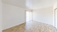 This efficiently designed two-bedroom, one-bathroom unit in Phoenix, Arizona offers a thoughtfully arranged single-floor layout. Throughout the space, light wood-look flooring creates a warm, cohesive feel, complemented by crisp white walls and abundant natural light.

The spacious primary bedroom features white-painted brick walls that add a subtle textural character, a sliding double-door closet, and a large sliding glass door dressed with vertical blinds that invite natural light while providing outdoor access. The second bedroom also showcases the same brick-textured walls, a window with blinds overlooking the exterior, and direct access to the hallway.

The kitchen is outfitted with granite countertops, white cabinetry, and full-size appliances including a refrigerator, providing a clean and functional workspace. A connecting hallway links the kitchen to the living areas, maintaining a practical flow throughout the unit.

The bathroom is well-appointed with a granite-topped vanity, a full-size soaking tub and shower combo with built-in shelving, and a small window that brings in natural light. A ceiling fan in the living area adds comfort suited to Phoenix's warm climate. Overall, the unit presents a clean, updated interior with consistent finishes that create a bright and welcoming atmosphere.
