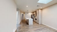Located in Golden, Colorado, this single-floor, 4-bedroom, 2-bathroom home showcases a clean, contemporary design with high-quality finishes throughout. The open-concept living and kitchen area serves as the heart of the home, anchored by a sleek kitchen island with a white quartz countertop and undermount sink. Light wood-grain cabinetry lines the kitchen walls, complemented by stainless steel appliances including a French door refrigerator and range, a tile backsplash, and stylish pendant lighting. Wood-look plank flooring extends across the main living areas, adding warmth and continuity. A dedicated laundry area and multiple closets provide practical storage solutions. The four bedrooms offer comfortable retreats, with select rooms featuring skylights that invite abundant natural light, and others showcasing plush carpet and large windows. The two bathrooms are finished with modern gray tile, glass-enclosed walk-in showers, wood-toned vanities, and tile flooring. The entryway greets residents with built-in wall hooks and durable flooring. Throughout, neutral tones, recessed lighting, and matte black hardware create a cohesive, contemporary aesthetic well-suited to the Golden, CO setting.