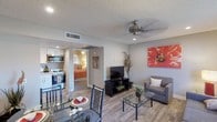 Located at 960 W Southern Ave in Mesa, Arizona, this single-floor residence offers a thoughtfully designed layout that balances comfort and functionality. The open-concept living and dining area is anchored by warm wood-look flooring, a ceiling fan, and recessed lighting, creating a bright and welcoming atmosphere. Bold artwork adds a vibrant pop of color to the neutral-toned walls, while a glass-top coffee table and plush seating complete the living space.

The dining area accommodates a glass-top table with seating for four and is accented by a framed wall mirror that adds depth to the room. Adjacent to the living space, the compact kitchen is outfitted with crisp white shaker-style cabinetry, granite countertops, a stainless steel sink, and stainless steel appliances, offering an efficient and stylish cooking environment.

The bedroom features plush carpeting, a ceiling fan, and a window dressed with layered curtains that allow for natural light control. A closet provides convenient storage within the room. The bathroom is finished with granite countertops, white shaker vanity cabinetry, a large mirror, wood-look tile flooring, and a soaking tub, lending a clean and polished feel throughout. This residence presents a cohesive, modern aesthetic from room to room.
