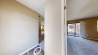 This single-floor residence in San Ramon, California offers a well-organized layout with a cohesive neutral color palette throughout. The entryway transitions from wood-look vinyl flooring into carpeted living areas, establishing a clear division between functional and relaxing spaces.

The living area is highlighted by a ceiling fan with light fixture, a window that draws in natural light, and a pass-through granite countertop connecting to the kitchen. The kitchen is fitted with light wood cabinetry, granite countertops, stainless steel appliances including a refrigerator and range, a built-in dishwasher, and wood-look vinyl flooring, providing a clean and functional workspace.

The bedrooms are generously sized with plush carpeting, ceiling fans, and ample natural light from multiple windows. One bedroom features a sliding glass door leading to an outdoor area, while another includes a walk-in closet. Both bathrooms are equipped with wood-look vinyl flooring, granite-topped vanities with light wood cabinetry, and full bathtub-shower combinations. The overall ambiance is bright, neutral, and move-in ready.