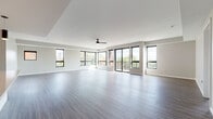 Located at 710 Jefferson Ave in Cleveland's vibrant Ohio City neighborhood, this single-floor residence offers a thoughtfully designed open-concept layout with high-quality modern finishes throughout. The expansive living area is a standout feature, boasting wide-plank hardwood-style flooring, a ceiling fan, and an impressive wall of black-framed windows and sliding glass doors that flood the space with natural light and open to a private balcony with outdoor views. The contemporary kitchen is well-appointed with white shaker cabinetry extending to the ceiling, stainless steel appliances including a refrigerator, microwave, and range, a large central island with a light quartz countertop, pendant lighting, and warm hardwood-style flooring. Multiple bedrooms feature plush carpeting, neutral-toned walls, and black-framed windows that bring in ample daylight. Closet space is provided in the bedrooms for convenient storage. The bathrooms are finished with light wood-look tile flooring, dark espresso vanities topped with white quartz countertops, and brushed nickel fixtures. One bathroom includes a full soaking tub and shower combination, while another features a separate shower. The overall aesthetic is clean, bright, and contemporary throughout.