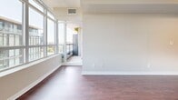 Located at 20 Lisgar Street in Toronto's sought-after Queen West neighbourhood, this one-bedroom, one-bathroom unit offers a well-designed layout across a single floor. Rich dark hardwood flooring flows throughout the main living areas, creating a warm and cohesive aesthetic complemented by neutral-toned walls and white baseboards.

The living room is a bright, open space anchored by floor-to-ceiling windows that frame sweeping city skyline views and flood the room with natural light. Sliding glass doors lead directly to a private balcony, extending the living space outdoors. The kitchen is efficiently designed with dark espresso cabinetry, granite-style countertops, a stainless steel sink, and black appliances, providing ample storage and prep space.

The bedroom is a comfortable, well-proportioned room featuring the same hardwood flooring and a sliding-door closet, with easy access to the rest of the unit. The bathroom is finished with light beige floor-to-ceiling tiles, a full soaking tub, and a vanity with dark wood cabinetry and a stone-topped countertop. A dedicated in-suite stacked washer and dryer closet in the hallway adds everyday convenience. The textured ceilings and clean finishes throughout give the unit a polished, functional character.