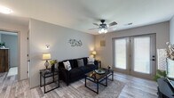 Located at 236 W Tracker Rd in Nixa, Missouri, this single-story home offers a cohesive, modern aesthetic with wood-look flooring flowing throughout every room. The living area is bright and welcoming, featuring a ceiling fan with integrated lighting, neutral gray walls, and a set of French doors that invite natural light and provide outdoor access. The kitchen is well-equipped and functional, showcasing gray shaker-style cabinetry with matte black hardware, granite-look countertops with a double basin sink, and black appliances including a range, over-the-range microwave, and refrigerator. Ample counter and cabinet space make it a practical workspace for everyday use. The home includes two bedrooms, each outfitted with ceiling fans, wood-look flooring, and soft neutral tones. One bedroom features a walk-in closet and a window for natural light, while the other offers convenient access to an adjacent bathroom. Both bathrooms continue the home's consistent design language, featuring wood-look flooring, and shower-tub combinations. The overall ambiance throughout is clean, cohesive, and move-in ready, with a neutral color palette that provides a versatile backdrop for a variety of interior styles.