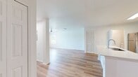 This modern 790 square foot apartment offers a thoughtfully designed living space with a single bedroom and bathroom. The open-concept layout seamlessly integrates the kitchen, living, and dining areas, creating a spacious feel. The kitchen boasts sleek, light-colored cabinetry, stainless steel appliances, and a convenient breakfast bar.

The bedroom, measuring 150 square feet, provides ample space and features large windows that invite natural light. The bathroom is efficiently designed with a single vanity and a shower/tub combination. A dedicated closet space ensures organized storage.

Throughout the apartment, warm-toned hardwood flooring adds a touch of elegance and continuity. Ceiling fans in the main living area and bedroom offer comfort and air circulation. Large windows in various rooms provide abundant natural light and views of the surrounding area.

The neutral color palette, predominantly white walls, creates a bright and airy atmosphere, allowing for personalized decor. This apartment combines functionality with modern aesthetics, making it an ideal choice for those seeking a contemporary living space.