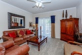 This single-story residence offers a thoughtfully organized layout that balances comfort and practicality throughout its interior spaces. The living room serves as the central gathering area, featuring plush carpeting, crown molding, a ceiling fan, and sliding glass doors that allow natural light to fill the space. A second seating area adjacent to the living room provides additional flexibility for relaxing or entertaining.

The galley-style kitchen is efficiently designed with cream cabinetry lining both sides, gray laminate countertops, a stainless steel sink, and white appliances including a range, microwave, and refrigerator. Wood-look flooring runs through the kitchen, extending into the dining area, which is an intimate space framed by neutral walls and lit by a pendant light overhead.

The bedroom is generously proportioned with soft carpet, a ceiling fan, and windows that bring in natural light. It connects directly to a full bathroom featuring a single-sink vanity with cabinet storage, a tub-shower combination with sliding glass doors, and wood-look flooring. A dedicated laundry area with overhead cabinetry and full-size washer and dryer hookups adds everyday convenience to the home.