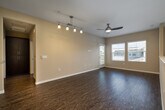 This single-floor residence at 5390 Camino Santander, Unit 229, in San Diego, CA, presents a thoughtfully designed layout with contemporary finishes throughout. The open living and dining area features durable wood-style flooring, neutral-toned walls, and a ceiling fan, creating a bright and comfortable atmosphere. A peninsula with a white countertop separates the living space from the kitchen, while a track lighting fixture adds focused illumination. Glass doors allow natural light to flow into the living area, enhancing the overall openness of the space.

The kitchen is well-equipped, featuring dark espresso cabinetry that extends to the ceiling for ample storage, white quartz-style countertops, and a decorative mosaic tile backsplash in neutral tones. Stainless steel appliances, including a refrigerator, gas range, microwave, and dishwasher, complete the functional cooking space.

The bedroom offers plush carpet flooring, warm neutral walls, and windows fitted with blinds for adjustable natural light. A double-door closet provides generous storage. The bathroom continues the modern aesthetic with large-format tile flooring, a soaking tub with tiled surround accented by mosaic tile detail, dark vanity cabinetry, and a white countertop with an integrated sink.