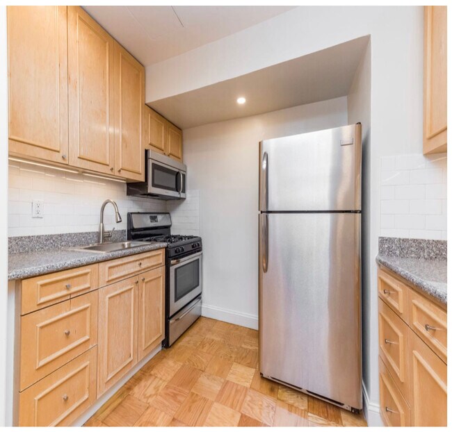 Kitchen with stainless steel appliances and under cabinet lighting. AMPLE kitchen storage space! The cabinets are wide and deep and easily fit appliances, such as crock pot, food processor, etc. as well as all your plates, cups, glasses, pots, and pans. - 2534 Crescent Street #LA