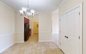 This single-floor residence offers a thoughtfully designed layout with a warm, neutral color palette throughout. The entryway greets visitors with elegant crown molding, light tile flooring, and a brushed nickel chandelier that sets a welcoming tone. A dedicated closet near the entrance provides convenient storage.

The galley-style kitchen is a standout feature, boasting rich cherry-toned cabinetry, dark granite-look countertops, a double stainless steel sink, and a full suite of black appliances including a refrigerator, electric range, built-in microwave, and dishwasher. Pendant lighting accents the space, and an open pass-through connects the kitchen to the dining and living areas.

The living room is particularly impressive, featuring dramatically vaulted ceilings, plush neutral carpeting, a ceiling fan, and a large picture window that invites natural light and outdoor views. The adjoining spaces maintain the same airy atmosphere with soaring wall heights.

The bedrooms are comfortably proportioned, each finished with soft carpeting and clean cream-toned walls. The bathrooms are finished with tile flooring, rich wood vanity cabinetry, and shower-tub combos with brushed nickel fixtures. The overall ambiance of this residence is clean, functional, and move-in ready.
