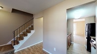 Located at 2209 Wabash Ct W in Columbus, Ohio, this two-story home offers a practical and comfortable layout across two well-defined levels. The main floor greets you with durable wood-style flooring that flows through the entryway and living areas. A staircase with an iron-railed banister connects the two levels, adding a classic architectural touch. The kitchen is equipped with warm medium-toned wood cabinetry, stone-patterned laminate countertops, a stainless steel sink, and upper shelving, providing ample storage and workspace. A sliding glass door in the living area fills the space with natural light and offers views of the outdoors. Upstairs, the bedrooms are finished with plush carpeting in neutral tones, creating a comfortable and quiet retreat. Several bedrooms feature standard closets with hanging rods, and windows throughout allow for natural light and outdoor views. The full bathroom includes a full-size soaking tub and shower combo with white surround, complemented by wood-style flooring and a white vanity. Warm beige and taupe wall tones are consistent throughout the home, contributing to a cohesive and neutral aesthetic that is move-in ready and easily personalized.