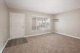Located at 1921 W La Veta Ave in Orange, CA, this single-floor, one-bedroom, one-bathroom unit offers a practical and comfortable layout. The living room is generously sized, featuring warm beige carpet, neutral-toned walls, a large window that invites natural light, and a direct access door. A ceiling fan with lighting is also present, enhancing comfort year-round. The space flows into a hallway that connects the main living areas to the bedroom and bathroom. The combined dining room and kitchen is equipped with white cabinetry, light-toned countertops, a gas range, refrigerator, and a double-basin sink beneath a window. Light wood-style flooring grounds the kitchen and dining area with a clean, cohesive look. The bedroom is well-proportioned, featuring plush carpeting, a ceiling fan with light fixture, a window with blinds, and a built-in closet with sliding doors. Additional storage is provided through multiple closets and a pantry distributed throughout the unit. A hallway connects all areas and includes access to the electrical panel. The textured ceilings and consistent neutral palette throughout lend the unit a simple, tidy aesthetic well-suited for everyday living.