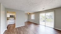 Located at 931 Spy Run Rd in Cumberland, Indiana, this two-bedroom, one-bathroom unit is thoughtfully laid out across a single floor. Wood-look flooring flows consistently throughout the space, complementing the neutral gray walls and crisp white trim found in every room. The open living and dining area is bright and welcoming, featuring a ceiling fan, a large window, and a sliding glass door fitted with vertical blinds that opens to an outdoor balcony with natural views. The kitchen is well-appointed with white shaker-style cabinetry, granite-look countertops, a stainless steel sink, and white appliances including a range, over-the-range microwave, and refrigerator. Both bedrooms offer comfortable proportions with textured ceilings and ample closet space — the primary bedroom notably includes two closets. The full bathroom is clean and functional, featuring a tub-shower combo, a white vanity with granite-look countertops, and wood-look flooring. Additional highlights include five closets throughout and a dedicated utility room, offering generous storage for everyday living. The unit's consistent finishes and practical layout make it a well-organized and move-in-ready home.