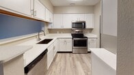Located at 35 Highland Rd in Bethel Park, PA, this single-floor residence offers a thoughtfully designed layout with a mix of modern finishes and comfortable living spaces throughout. The kitchen is well-appointed with crisp white shaker cabinetry, light quartz countertops, a stainless steel range, over-the-range microwave, dishwasher, and a undermount sink — all set atop light wood-look luxury vinyl plank flooring that adds warmth and durability. The open living area features the same wood-look flooring and is bathed in natural light through sliding glass doors that open to an outdoor balcony, creating a seamless indoor-outdoor connection. The bedrooms are generously sized, finished with plush carpeting and large windows that invite abundant natural light and views of the surrounding greenery. Additional flexible rooms with wood-look flooring provide versatile spaces for a home office or den. The bathrooms are clean and functional, with one featuring a wide vanity with white cabinetry, quartz countertops, wood-look flooring, and a separate shower area, while another offers a full tub-shower combination with white tile surround. Neutral taupe wall tones and textured ceilings tie the space together with a cohesive, understated aesthetic throughout.