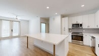 Located in Brookshire, TX, this single-story 2-bedroom, 2-bathroom home delivers a clean, modern aesthetic through a thoughtfully designed open-concept layout. Light wood-look flooring flows through the main living areas, complemented by recessed lighting and a bright, neutral color palette that enhances the sense of openness throughout.

The kitchen serves as the centerpiece of the home, showcasing a large white quartz island with seating, white shaker-style cabinetry with matte black hardware, a classic subway tile backsplash, and stainless steel appliances including a refrigerator, range, microwave, and dishwasher. The island connects seamlessly to the living area, creating an ideal open-concept space for everyday living and entertaining.

The primary bedroom features light wood flooring, a ceiling fan, and French doors providing access to the outdoors. It is supported by a generously sized walk-in closet with dual hanging rods and shelving. The en-suite bathroom offers a white vanity with modern fixtures and a glass-enclosed walk-in shower with large-format tile.

The second bedroom is carpeted, benefits from natural light through a window, and includes its own walk-in closet. Both bedrooms and bathrooms maintain the home's consistent modern design sensibility.