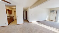 Located at 7717 Carrington in Madison, WI, this single-floor, two-bedroom, one-bathroom unit offers a functional and comfortable layout. The open living room is generously sized, featuring neutral wall-to-wall carpeting, baseboard heating, and a sliding glass door that fills the space with natural light while providing views of the surrounding area. A wall-mounted air conditioning unit adds year-round climate flexibility.

The kitchen is efficiently designed with tile flooring, warm oak cabinetry, laminate countertops, and a full suite of stainless steel appliances including an electric range, microwave, refrigerator, and dishwasher. A convenient passthrough connects the kitchen to the rest of the unit.

Both bedrooms are carpeted and bright, each featuring windows with red-trimmed frames that allow in natural light and baseboard heating units. The spacious primary bedroom includes a ceiling fan and access to a dedicated closet. The second bedroom is well-proportioned and similarly finished.

The full bathroom is finished with tile flooring, an oak vanity with a granite-style countertop, a large mirror, and a multi-bulb light fixture. Consistent warm wood tones and neutral finishes throughout the unit create a cohesive and welcoming ambiance.